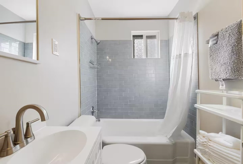 Bathroom with shower / bath combo with shower curtain and vanity