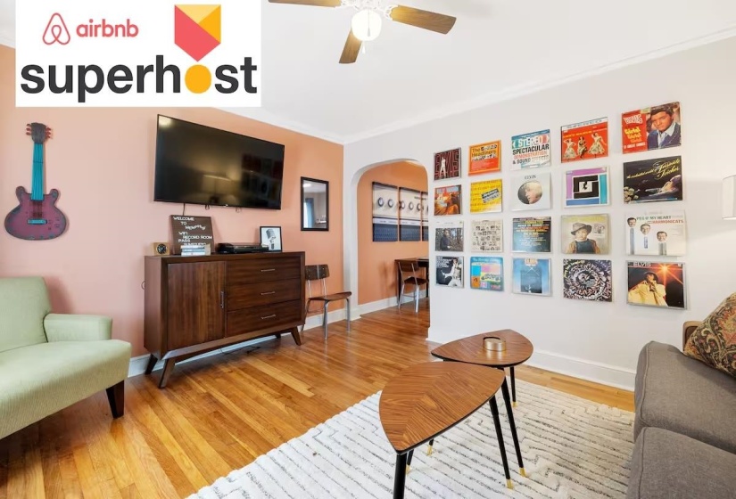 Sitting room featuring wood finished floors, arched walkways, crown molding, and ceiling fan