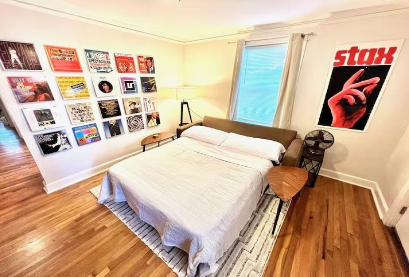 Bedroom with wood finished floors and ornamental molding