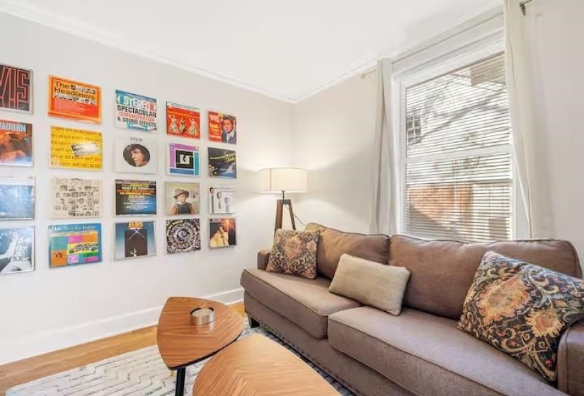 Living area with wood finished floors and ornamental molding