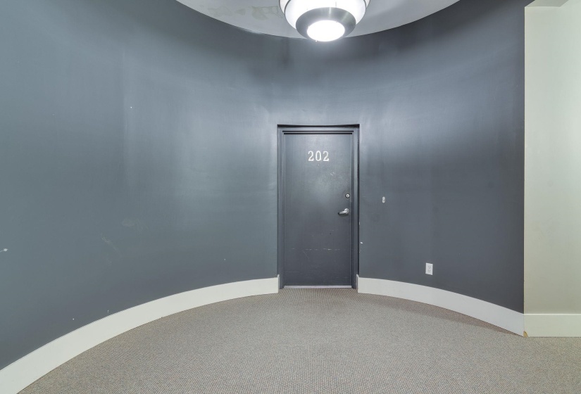 Unfurnished room featuring baseboards and light carpet