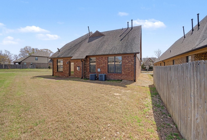Back of property with roof with shingles and brick siding