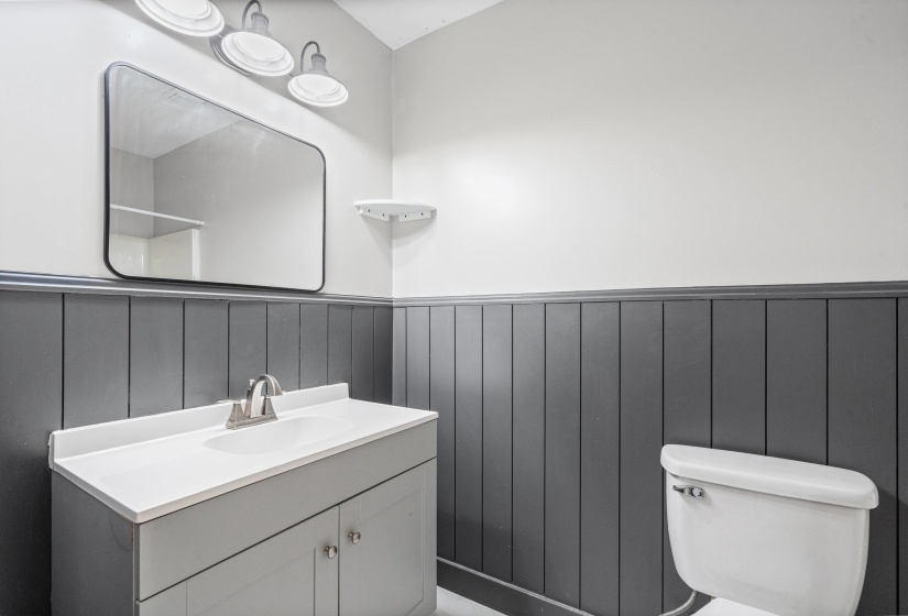 Half bathroom featuring vanity and wainscoting
