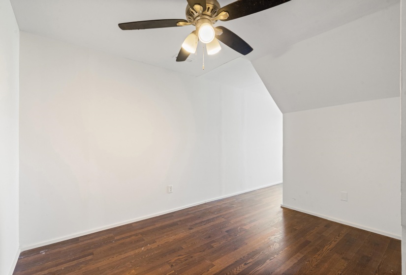 Additional living space with lofted ceiling, dark wood-style flooring, and a ceiling fan