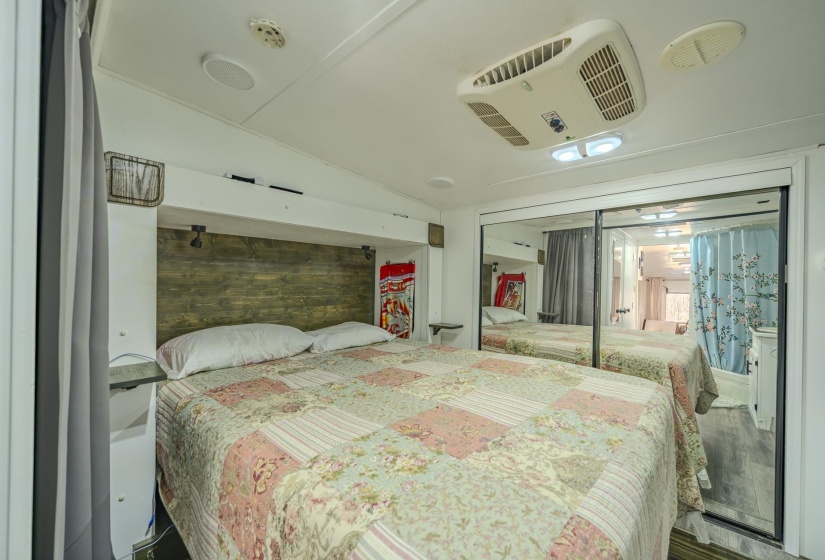 Bedroom with lofted ceiling, wooden walls, and a closet