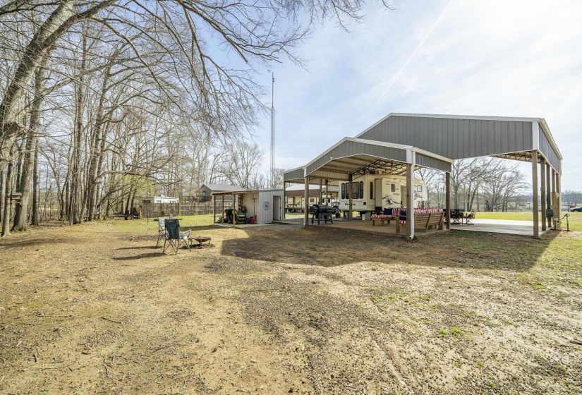 View of grassy yard featuring a patio area and an outbuilding