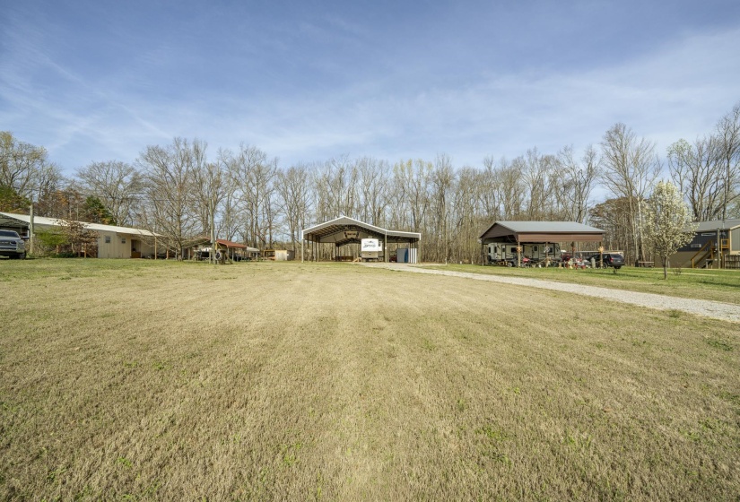 View of green lawn with a detached carport