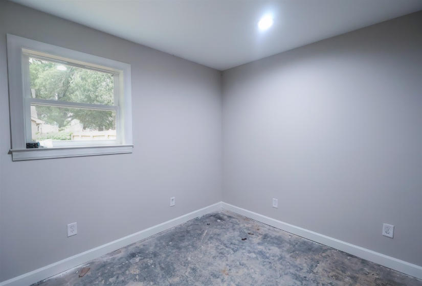 Empty room featuring baseboards and concrete flooring