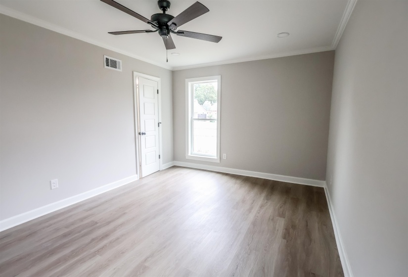 Spare room with light wood-type flooring, ornamental molding, and ceiling fan