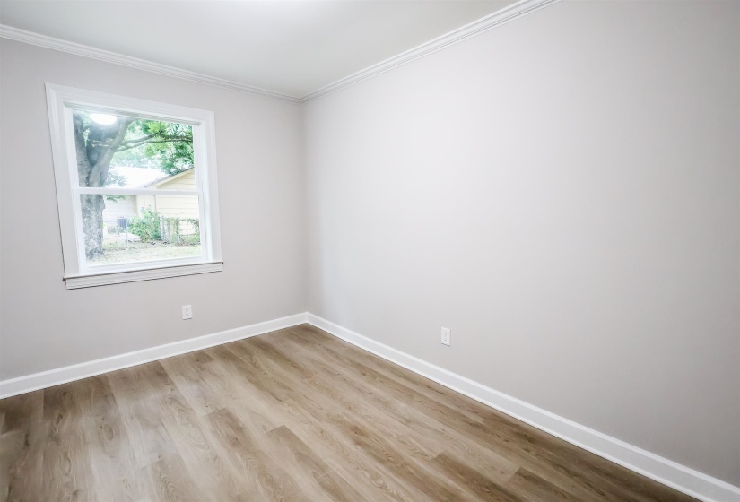 Spare room with light wood-style flooring and ornamental molding