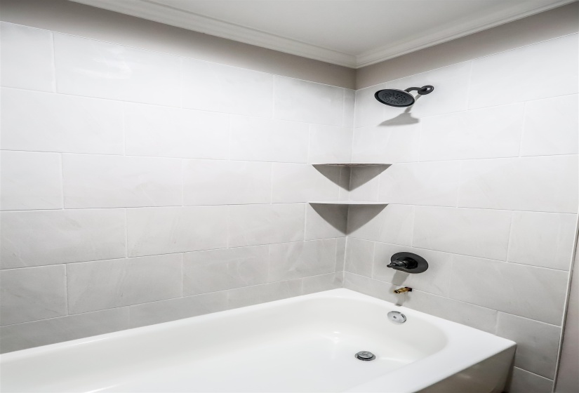 Full bath with shower / bathtub combination and ornamental molding
