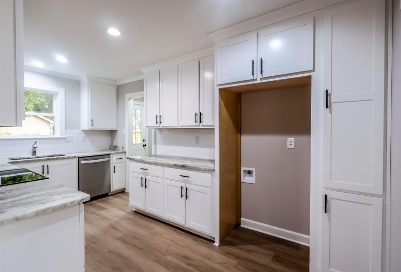 Kitchen with light wood-type flooring, white cabinetry, stainless steel dishwasher, recessed lighting, and light stone countertops