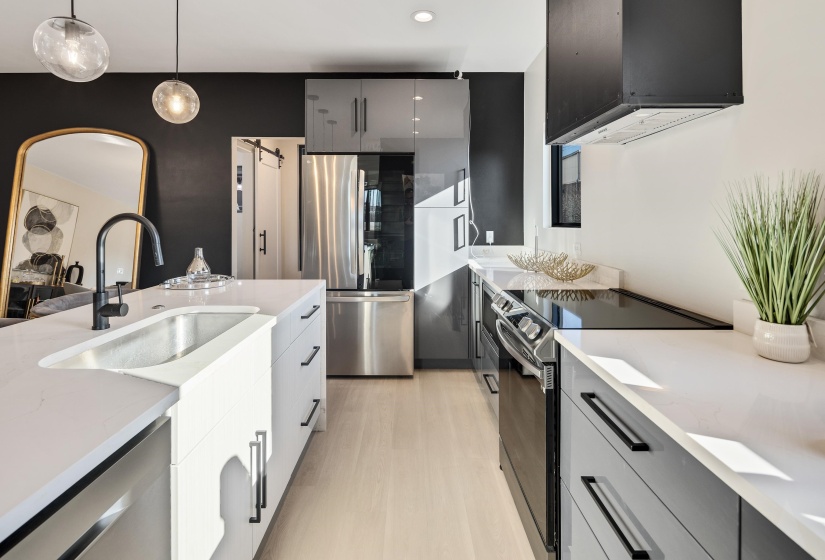 Kitchen featuring appliances with stainless steel finishes, exhaust hood, pendant lighting, light stone countertops, and modern cabinets