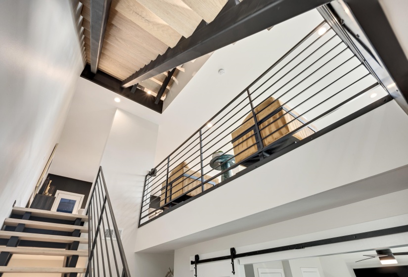 Stairs featuring a towering ceiling and beamed ceiling