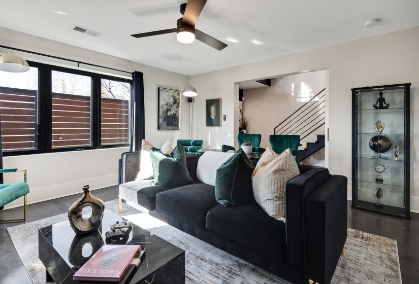 Living area with stairs and ceiling fan