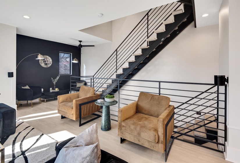 Living room with recessed lighting, wood finished floors, stairway, and an accent wall