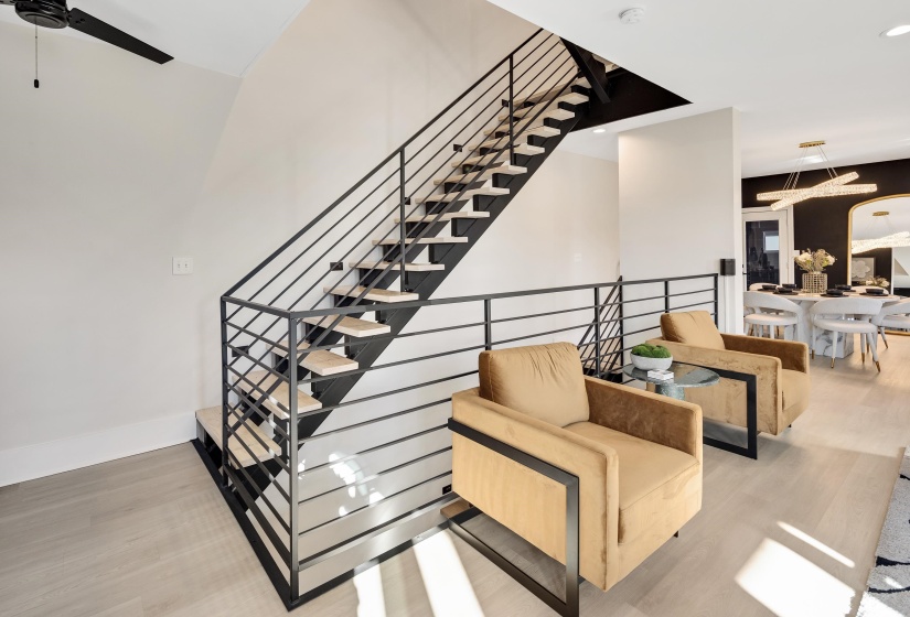 Stairs featuring wood finished floors and ceiling fan