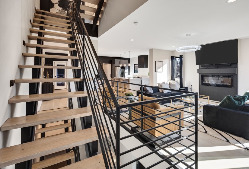 Stairs with a glass covered fireplace, recessed lighting, and a chandelier