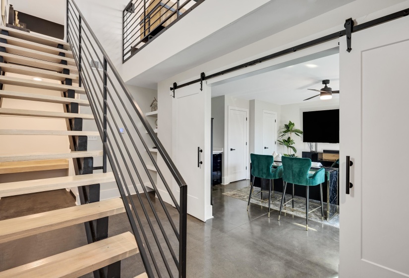 Stairs featuring a barn door and concrete flooring