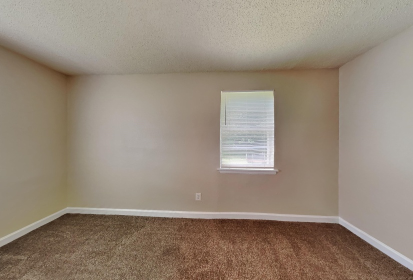 Unfurnished room with a textured ceiling and dark carpet