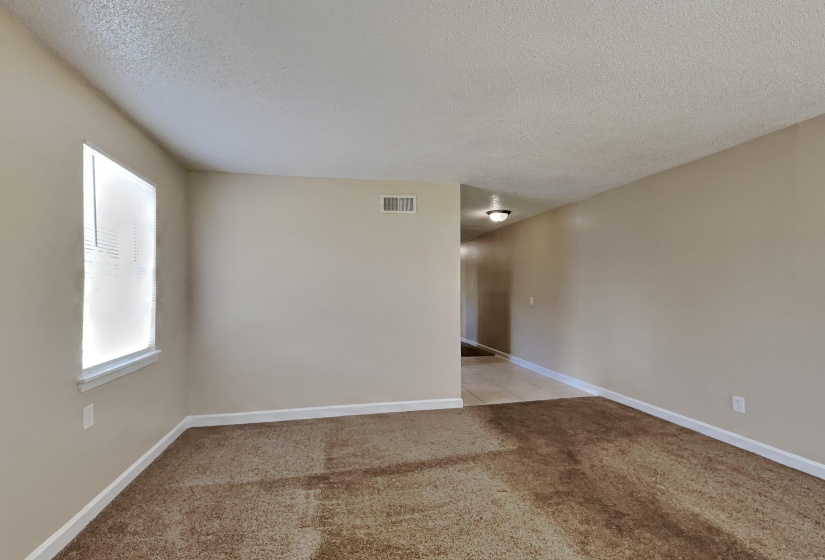Unfurnished room with light colored carpet and a textured ceiling
