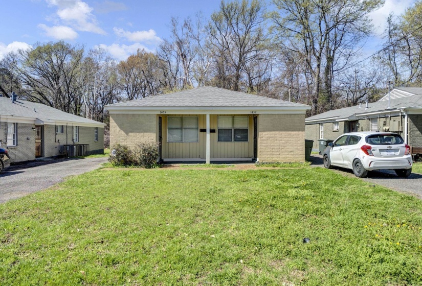 View of front of property with a front yard and brick siding