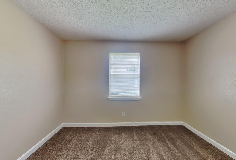 Unfurnished room with dark colored carpet and a textured ceiling