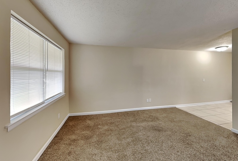 Empty room featuring light carpet and a textured ceiling