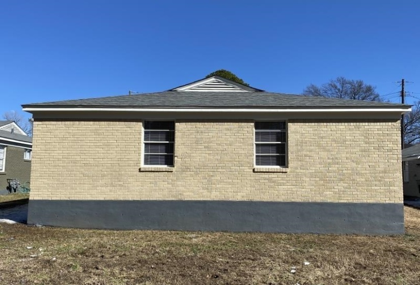 View of home's exterior with brick siding and roof with shingles