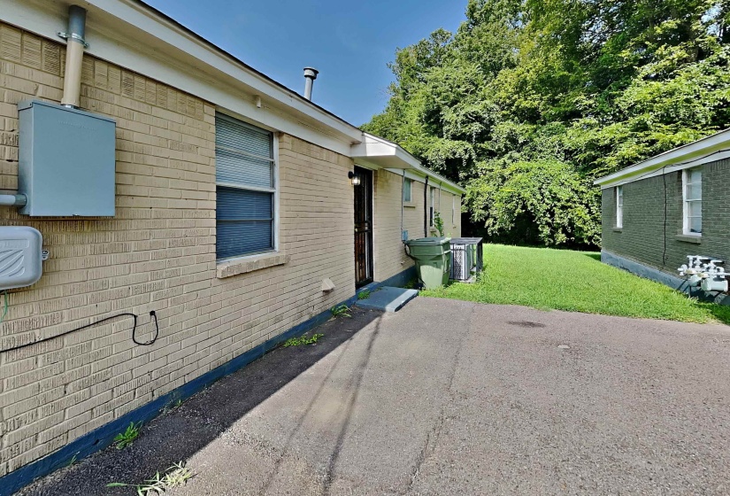 View of property exterior with a yard and brick siding