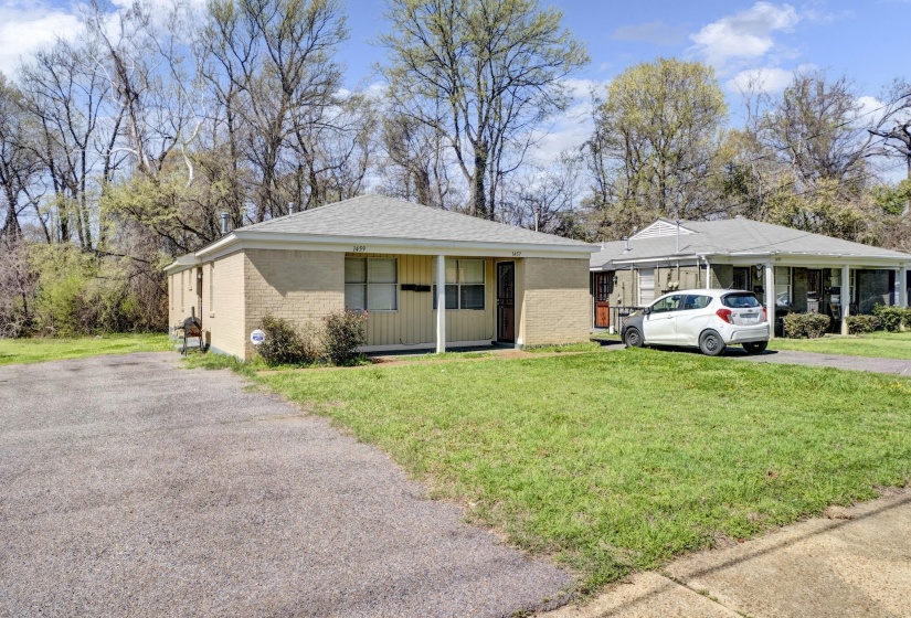View of front of property with a front yard, brick siding, asphalt driveway, and roof with shingles