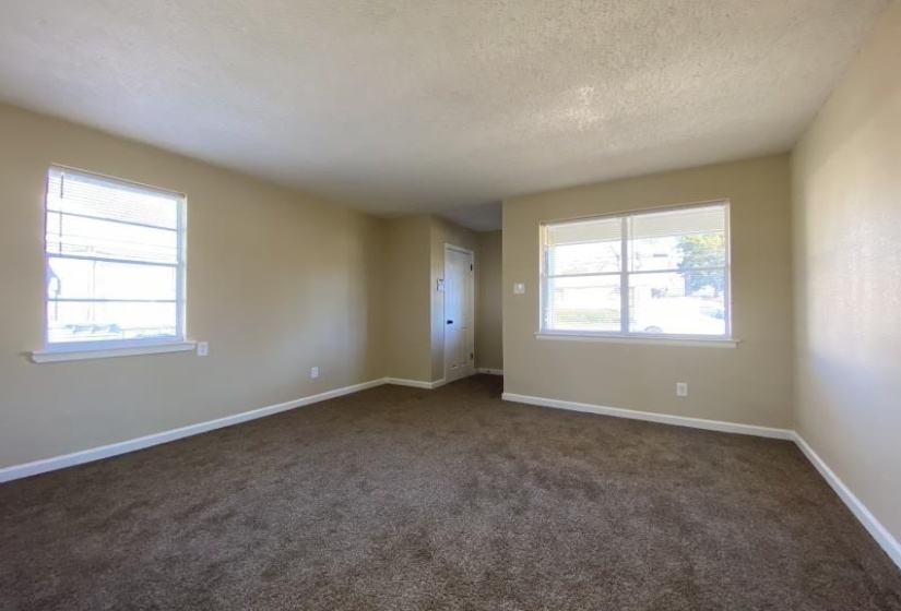 Empty room featuring dark colored carpet and a textured ceiling