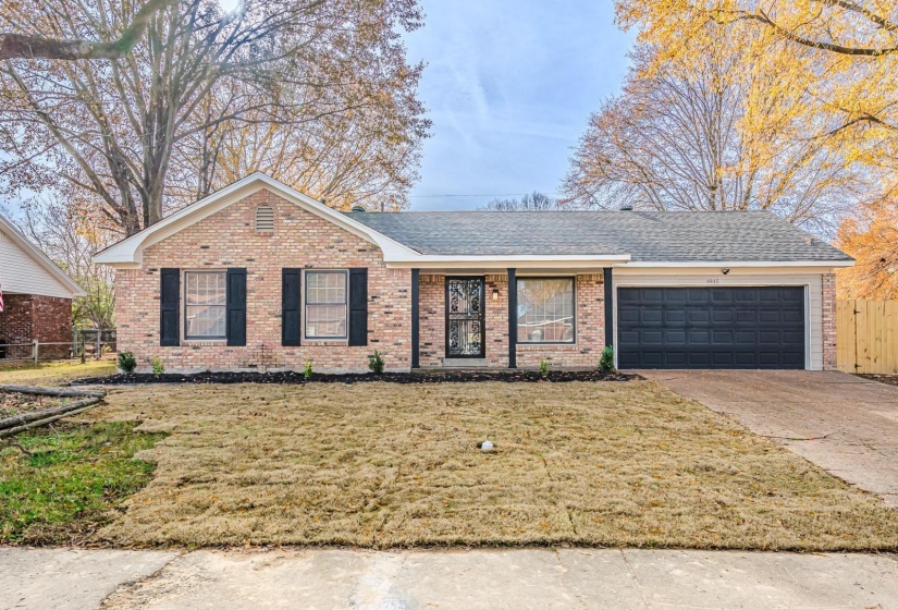 Ranch-style home featuring an attached garage, concrete driveway, brick siding, and a shingled roof