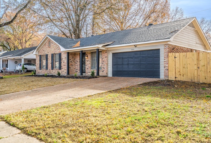 Single story home with an attached garage, driveway, brick siding, a shingled roof, and a gate