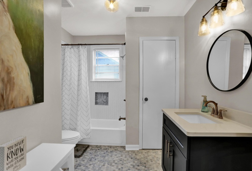 Bathroom with shower / bath combination with curtain, vanity, visible vents, and toilet