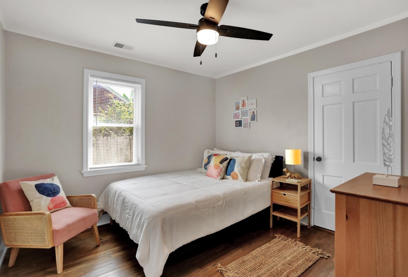 Bedroom featuring crown molding, visible vents, ceiling fan, and wood finished floors