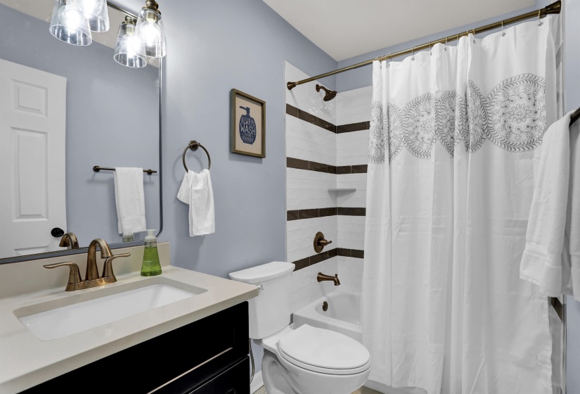 Full bathroom featuring shower / bathtub combination with curtain, vanity, and toilet