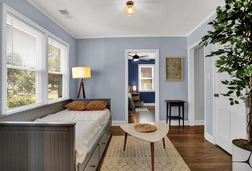Bedroom with crown molding, visible vents, baseboards, and wood finished floors