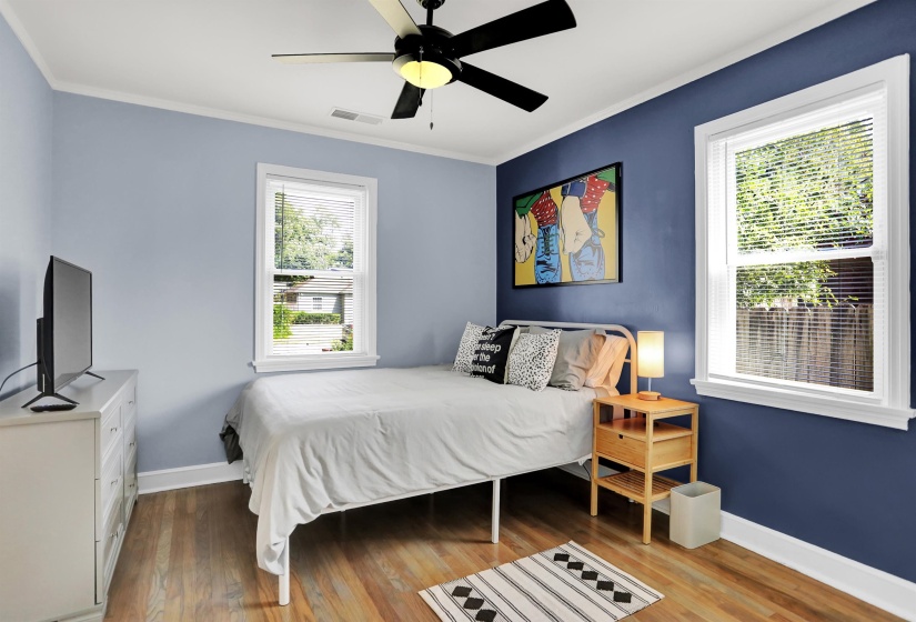 Bedroom featuring ornamental molding, visible vents, baseboards, and wood finished floors
