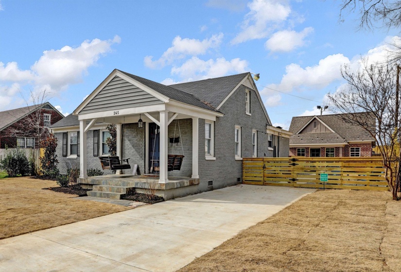 View of front facade featuring brick siding, a porch, fence, and crawl space