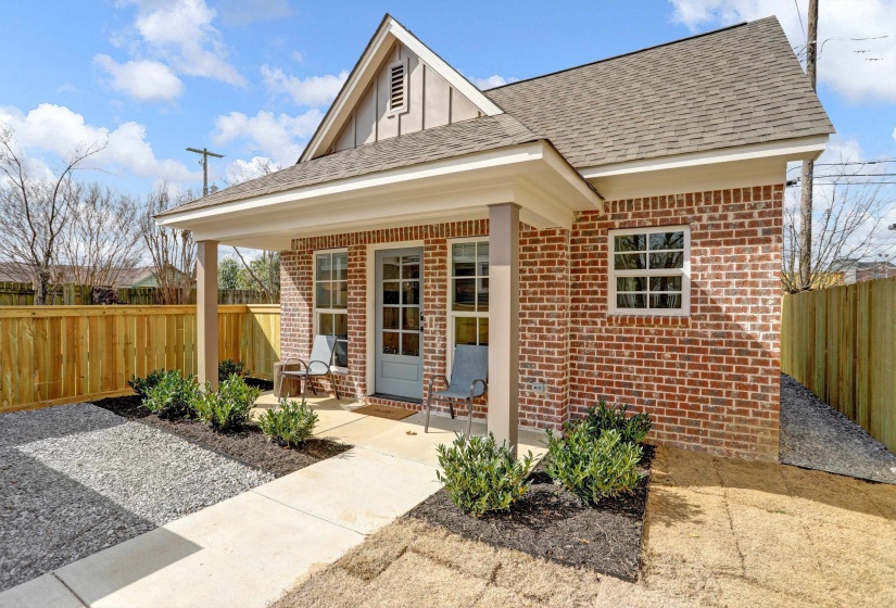 Exterior space with a patio, a shingled roof, a fenced backyard, and brick siding