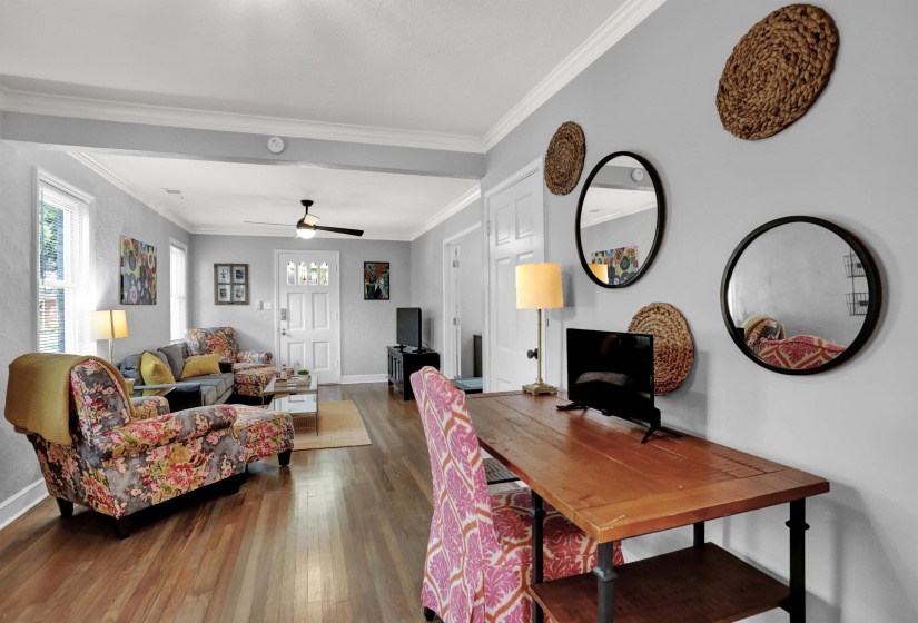 Dining room featuring baseboards, hardwood / wood-style flooring, crown molding, and ceiling fan