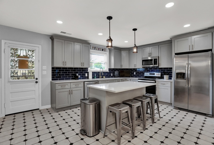 Kitchen with visible vents, gray cabinetry, light floors, and stainless steel appliances