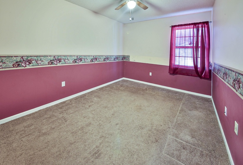Spare room with ceiling fan, light colored carpet, and a textured ceiling