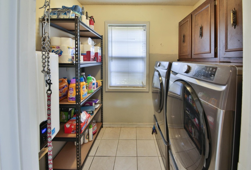 Laundry room with light tile patterned floors and washer and clothes dryer