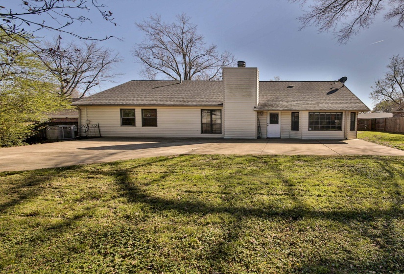 Rear view of property with a chimney, a patio, and roof with shingles
