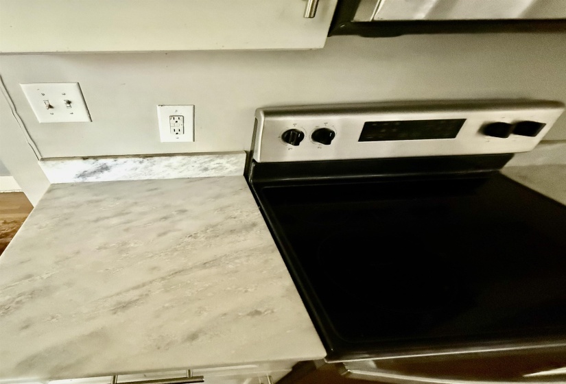 Kitchen view of electric range and light countertops