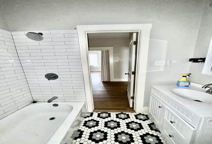 Full bath with vanity, dark tile patterned flooring, and shower / bathtub combination