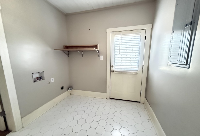 Laundry area with hookup for a washing machine, electric panel, and hookup for an electric dryer
