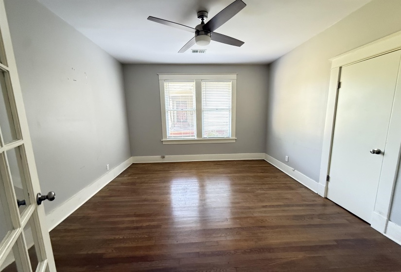 Unfurnished bedroom with dark wood-style floors and ceiling fan